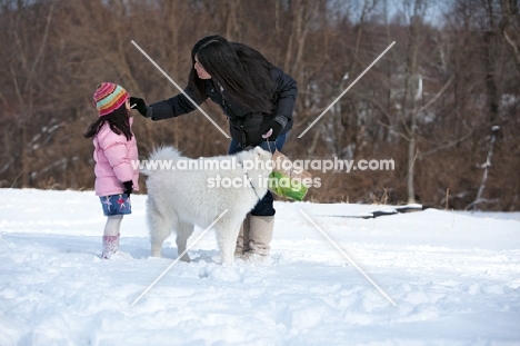 Samoyed dog with woman and girl