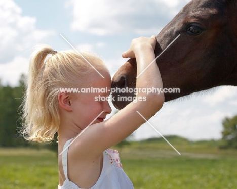 girl hugging young Appaloosa horse