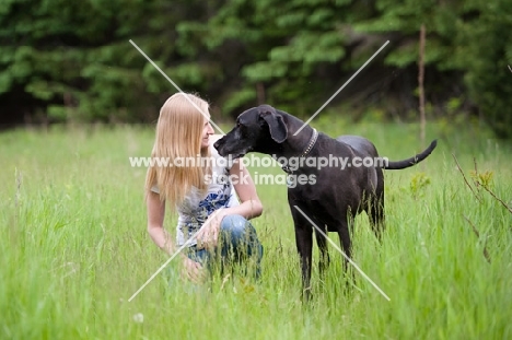 Woman kneeling with Great Dane.