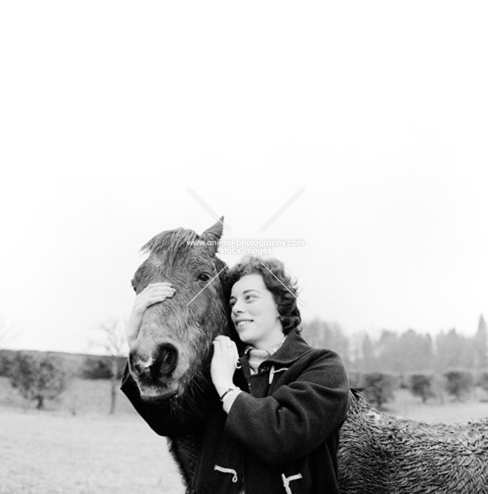 owner embracing her very wet horse