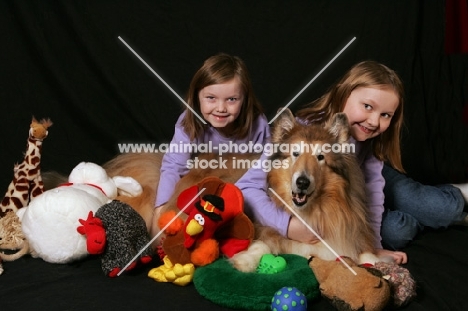 girls with Rough Collie and toys