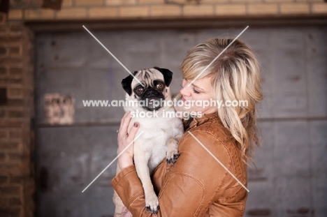 female holding fawn Pug