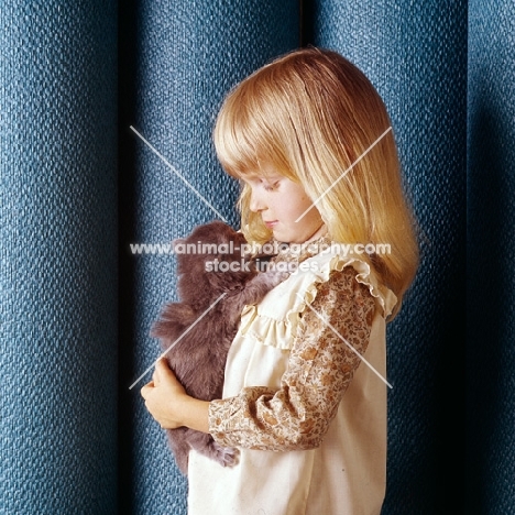 child holding Persian tortoiseshell kitten