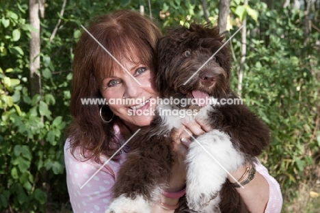 woman hugging her young Portuguese Water Dog
