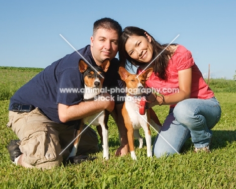 two basenjis and their owners