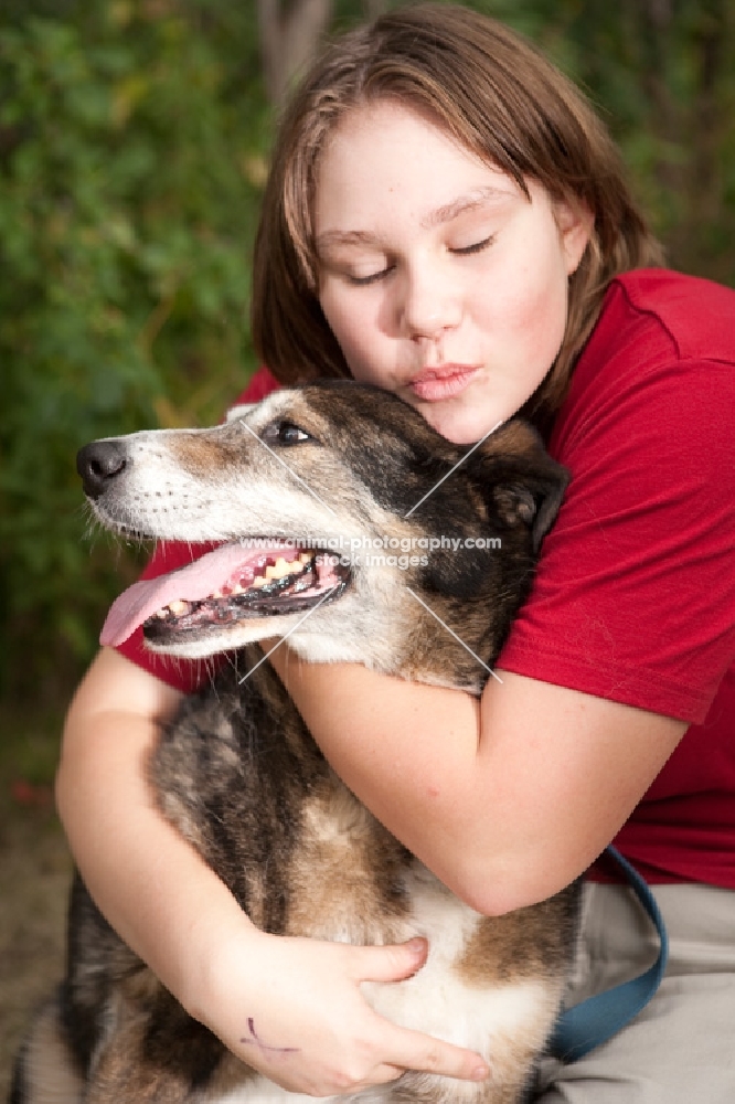 Girl hugging her German Shepherd mix dog.