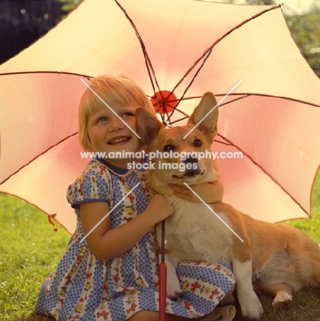 girl and corgi under parasol looking forward and smiling