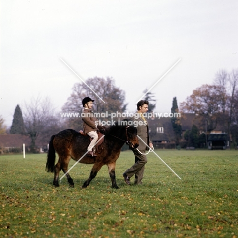 child riding pony being led on leading rein