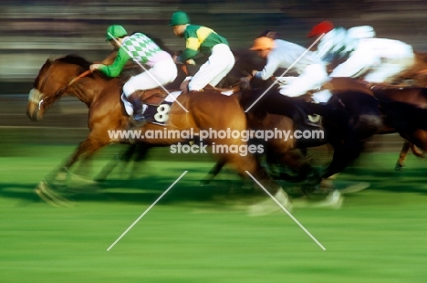 horses and jockeys racing at racecourse