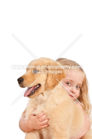 girl hugging her puppy on wooden floor