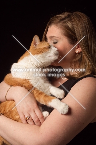 woman cuddling red and white cat