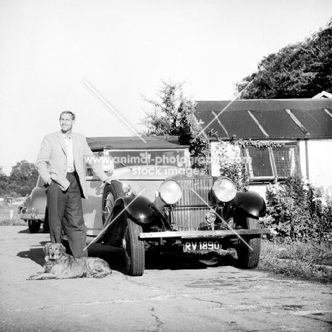 tall man with his golden retriever and vintage rolls royce