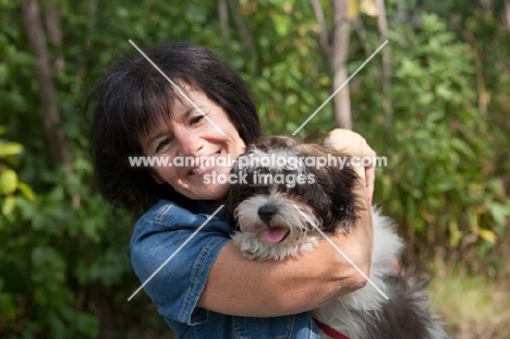 Woman hugging her Shih Tzu dog.