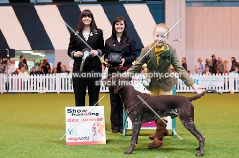 "Morgan" ShCh Kavacanne Toff at the Top JW and handler posing for photos after a win in their handling category at Crufts 2012 with judge.