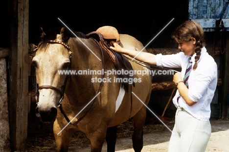 girl measuring stirrup leather length