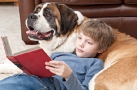 Picture of boy reading a book with Saint Bernard