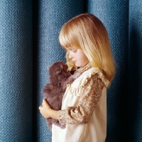 Picture of child holding Persian tortoiseshell kitten