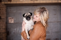 Picture of female holding fawn Pug