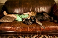 Picture of girl and dog asleep on a couch