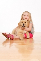 Picture of girl and puppy on wooden floor