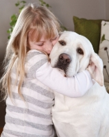 Picture of girl hugging a Labrador