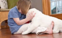 Picture of girl kissing Labrador puppy