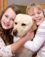 Picture of girls hugging a Labrador