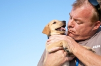 Picture of man holding labrador puppy