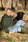 Picture of man sitting with black labrador