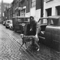 Picture of man with a greyhound in a cobbled street