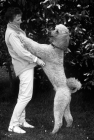 Picture of proud undocked standard poodle standing up with owner,  wendy harris