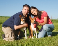 Picture of two basenjis and their owners