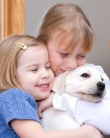 Picture of two girls with Labrador puppy