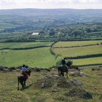 Picture of two riders in distance on dartmoor ponies, one is shilstone rocks barbados ridden by jo, on the moor, 