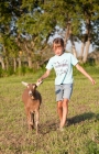 Picture of young girl playing with her young Alpine dairy goat kid