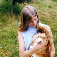 Picture of young woman cuddling a pekingese